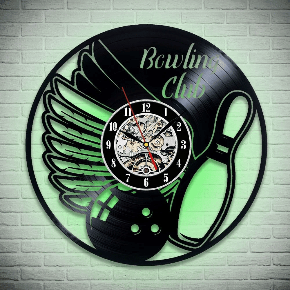 Black vinyl record clock with bowling ball and wings design, illuminated with a green light effect, showcasing detailed gears.