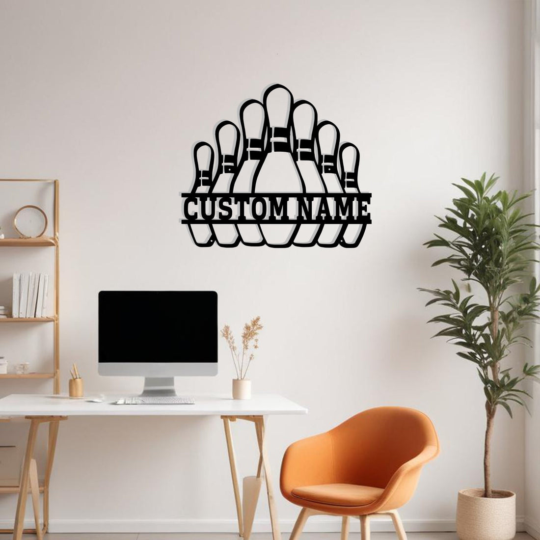 Black metal bowling pins wall art with “Custom Name” cutout displayed above a modern office desk setup with computer monitor and an orange accent chair