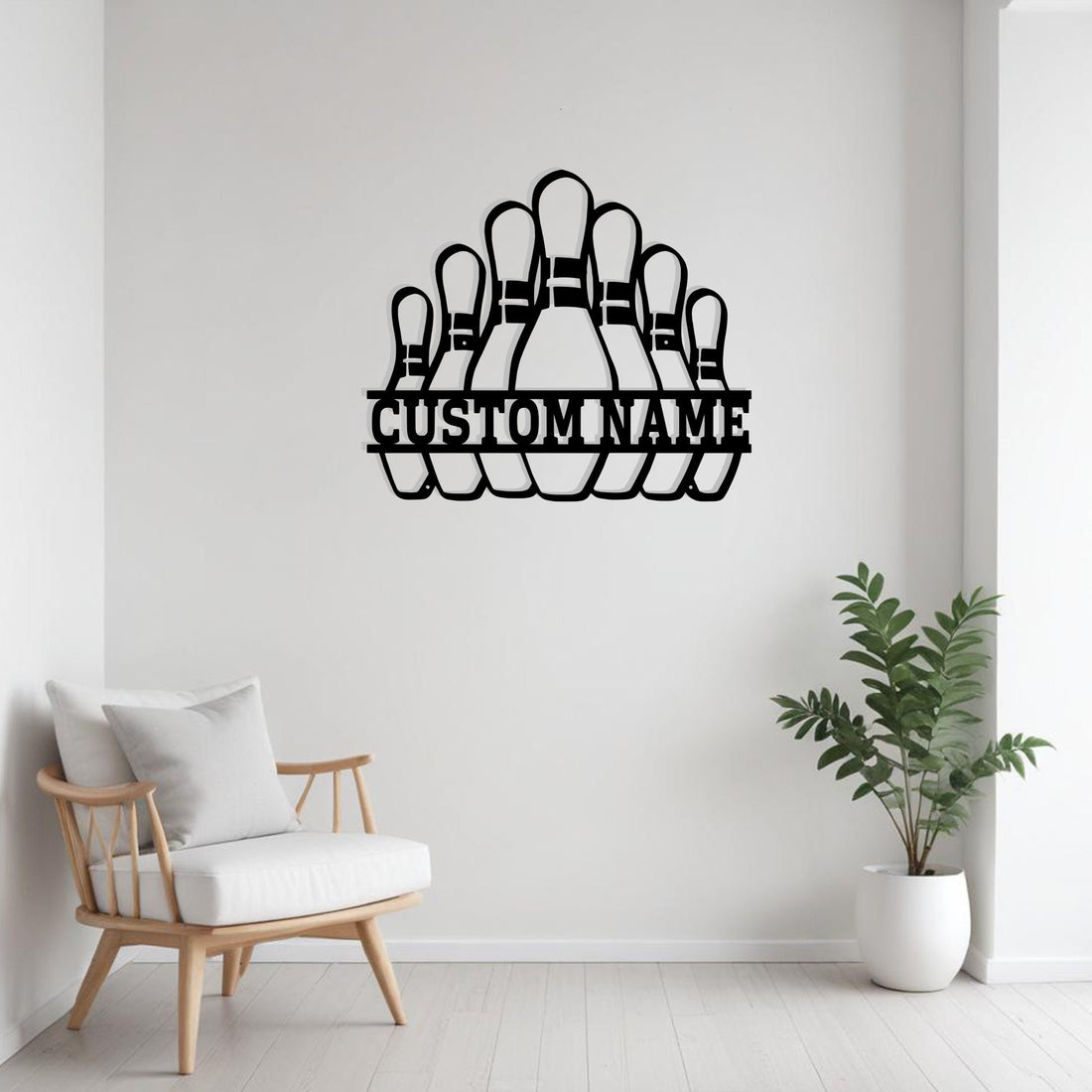 Black metal bowling pins wall art with “Custom Name” cutout displayed above a modern office desk setup with computer monitor and an orange accent chair