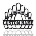 Close-up of black metal bowling pin sign with customizable name section, isolated on white background with reflection.
