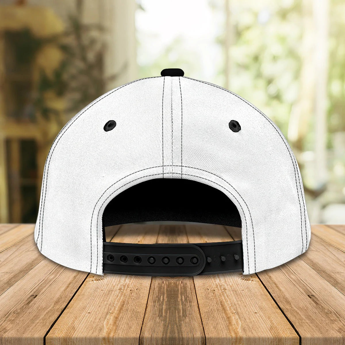 Alt text: “Back view of white and black snapback bowling cap showing adjustable plastic strap”
