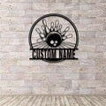 Black round bowling sign displayed on a textured stone wall, showcasing laser-cut detail of pins, ball, and personalized text panel.