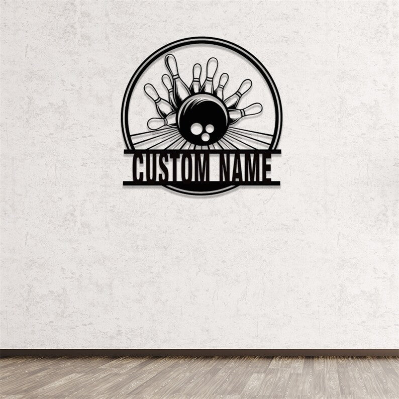 Powder-coated black metal bowling sign mounted on a smooth white wall, featuring a bowling ball and pins in a round frame with custom name bar.