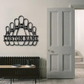 Bowling pins wall art with custom name displayed next to a tall gray door in a minimalist home.